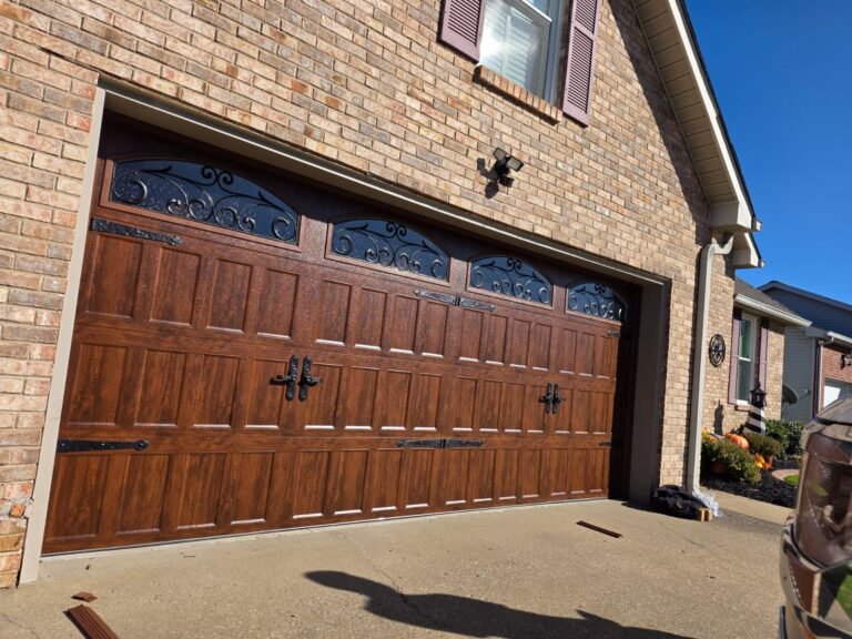 Premium wood-look garage door with wrought-iron accent windows on a brick home