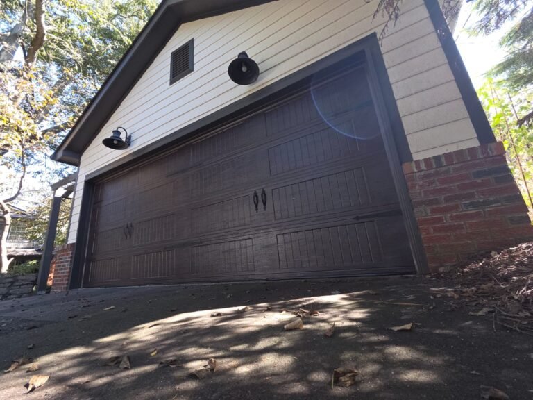 Dark walnut carriage-style garage door on a tan brick home