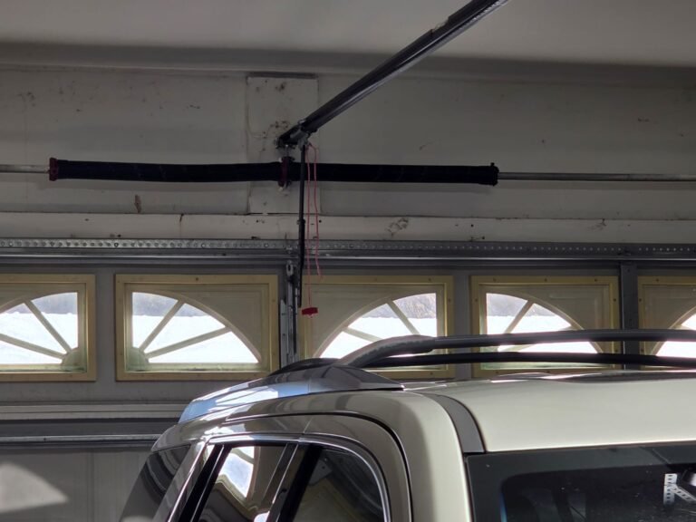 Torsion spring and opener rail above a garage door, close-up